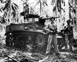 Nov. 4, 1942: Two alert U.S. Marines stand beside their small tank on Guadalcanal in the Solomon Islands during World War II. The military tank was used against the Japanese in the battle of the Tenaru River during the early stages of fighting. (AP Photo)